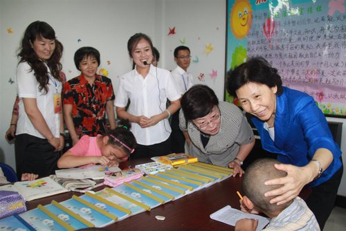 Vice President and Member of the Secretariat of the ACWF Zhao Donghua (R) talks to the children at the Changtong Community children's home while evaluating the Action Against Infant Anemia project implementation in Baiyin City, northwest China's Gansu Province, on July 17, 2013. [baiyinqu.cn] 