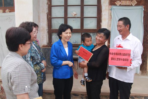 Vice President and Member of the Secretariat of the ACWF Zhao Donghua (C) visits a family and presents them with nutritional packages and gift money while evaluating the Action Against Infant Anemia project implementation in Baiyin City, northwest China's Gansu Province, on July 17, 2013. [baiyinqu.cn]