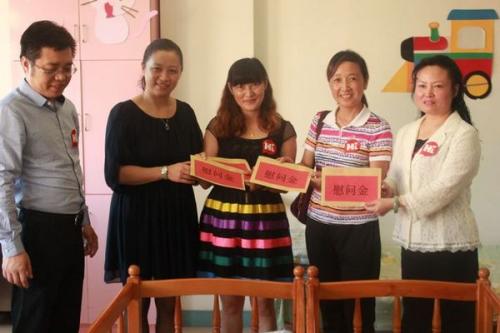 Working staff of the China Children and Teenagers' Foundation (CCTF), representatives from southwest China's Guizhou Women's Federation and charitable enterprises present subsidies to the disabled children in the welfare home in Guiyang, capital of southwest China's Guizhou Province, on September 9, 2013. [Guizhou Women's Federation]