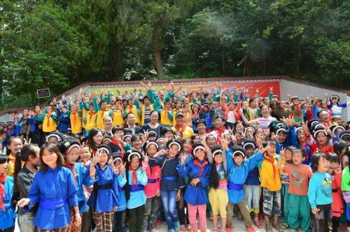 Working staff of the China Children and Teenagers' Foundation (CCTF), representatives from southwest China's Guizhou Women's Federation and charitable enterprises take a group photo with rural children on September 9, 2013. [Guizhou Women's Federation]