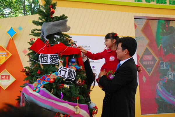 陈忠伟总经理与香港的小朋友将爱心挂上圣诞树，祝福孤残儿童健康成长。