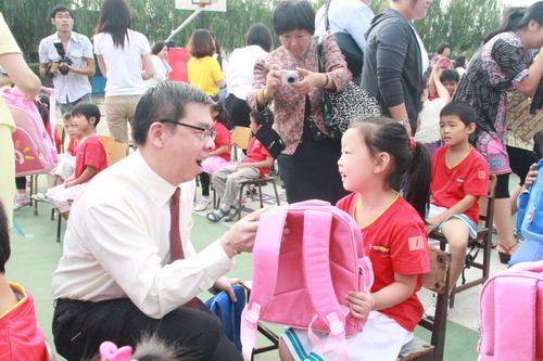 凯德商用中国总裁骆伟汉为新入学的孩子赠送书包