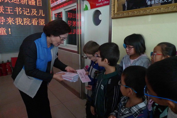 新疆自治区妇联党组书记王建玲向孩子们发放慰问金