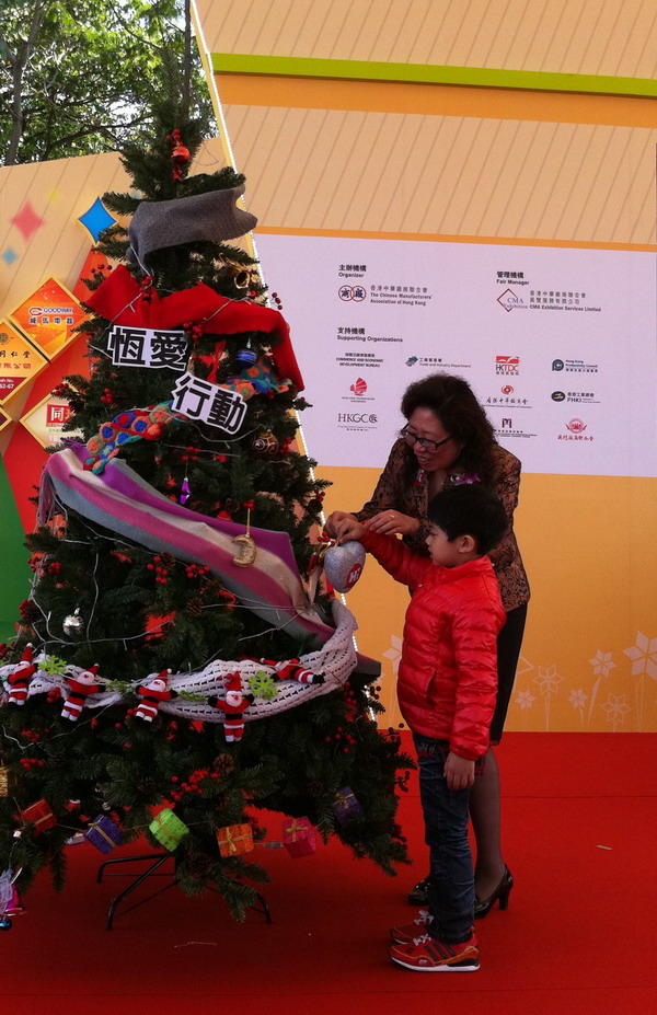 陈晓霞秘书长与香港的小朋友将爱心挂上圣诞树，祝福孤残儿童健康成长。