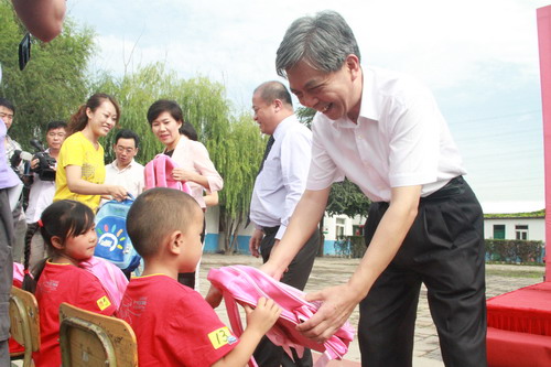 北京市委副秘书长王翔为新入学的孩子赠送书包