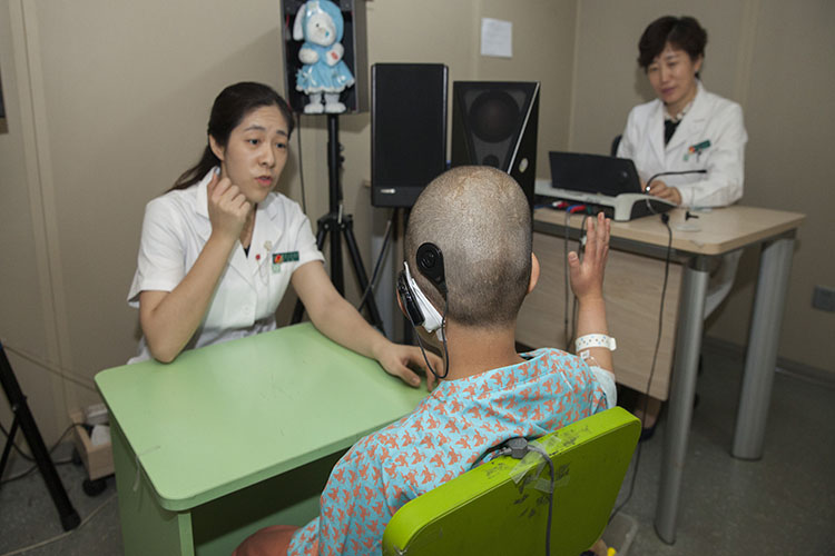 做完人工耳蜗植入手术的患儿与医生在沟通   魏星 摄.JPG