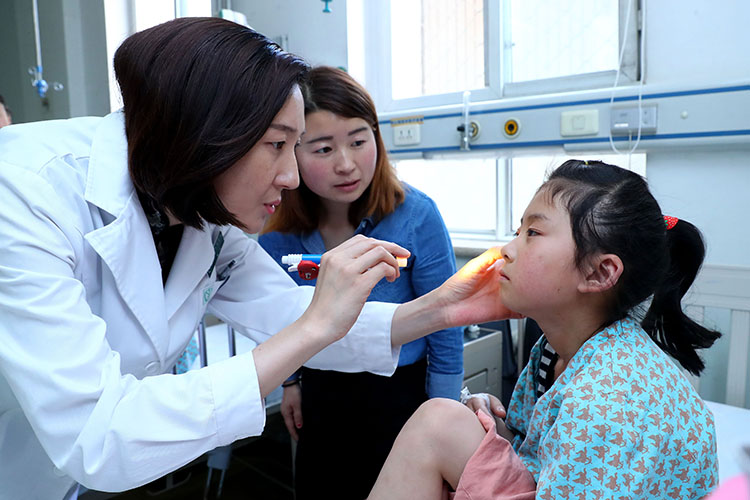 北京儿童医院医生为一名做完手术的视障孩子做检查 魏星 摄.jpg