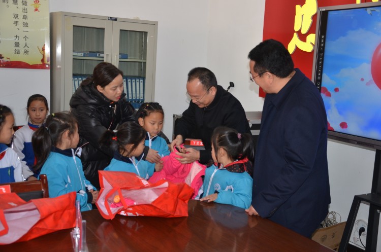 中国儿童少年基金会秘书长朱锡生为春蕾女童穿上捐赠的新衣服.jpg
