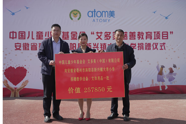 1儿基会与艾多美代表向学校递.jpg