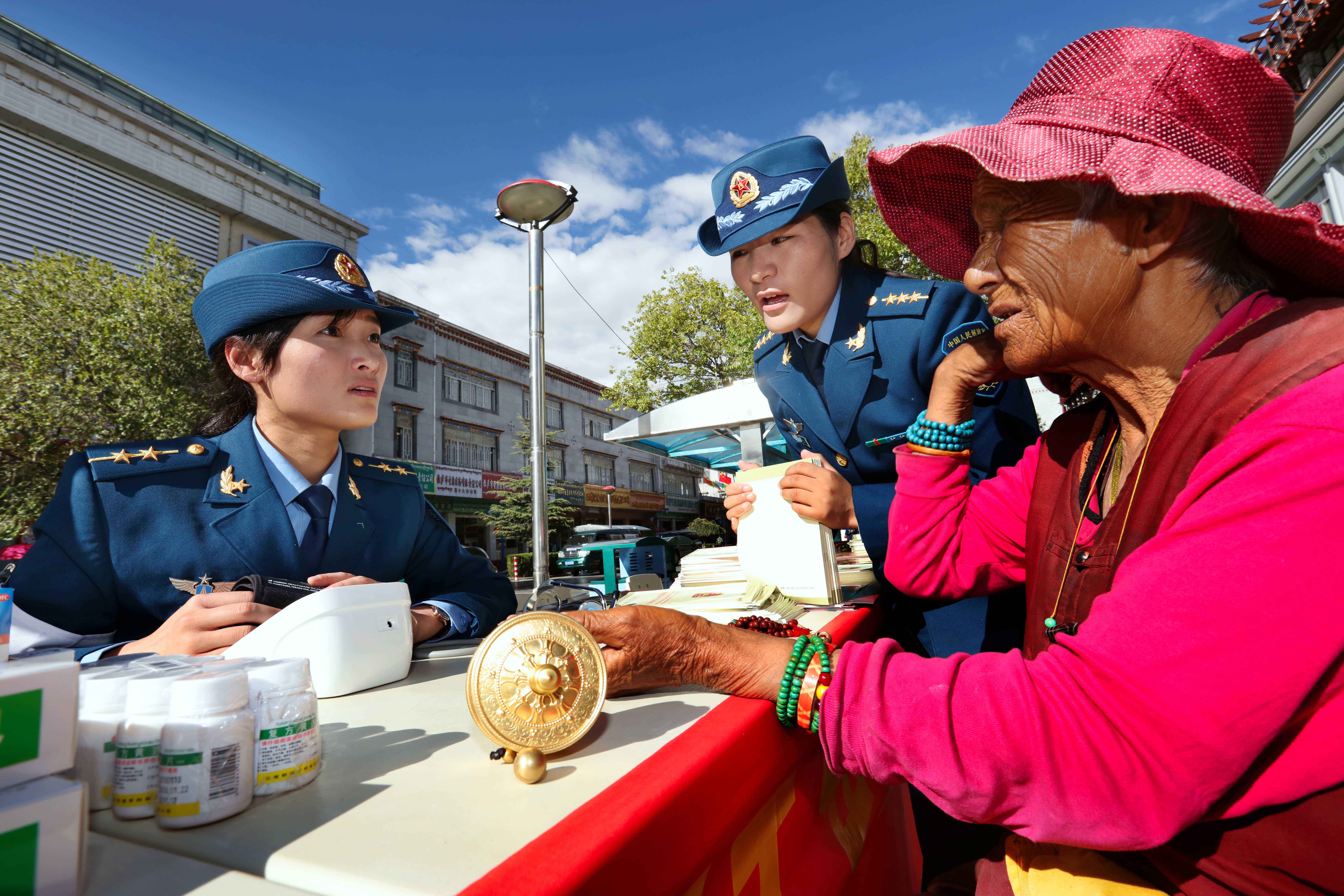 驻藏空军官兵在拉萨街头为群众进行义务巡诊，索朗（中间）负责组织活动并担负翻译工作。.jpg